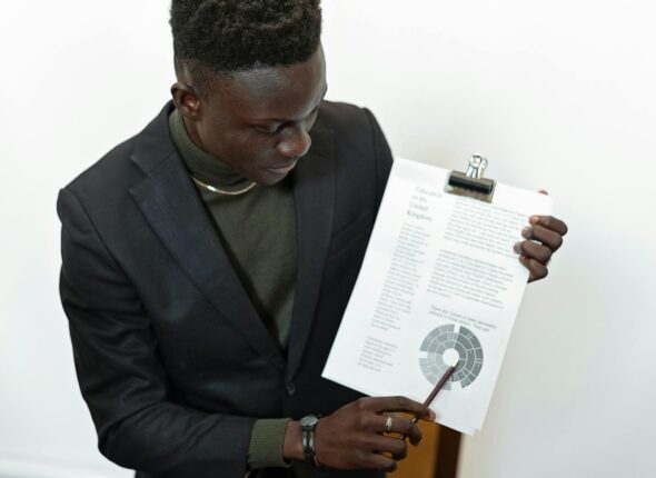 Professional businessman presenting financial report using a clipboard, highlighting important data.