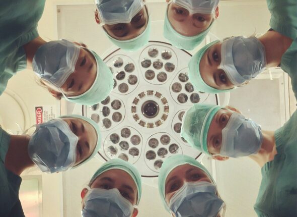surgeons looking down under operating light